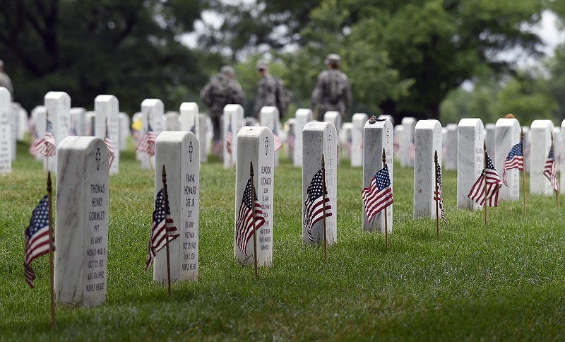 Members of the 3rd U.S. Infantry Regiment (The Old Guard) place a flag in front of each headstone at Arlington National Cemetery in Arlington, Va., in this May 21, 2015, photo. 