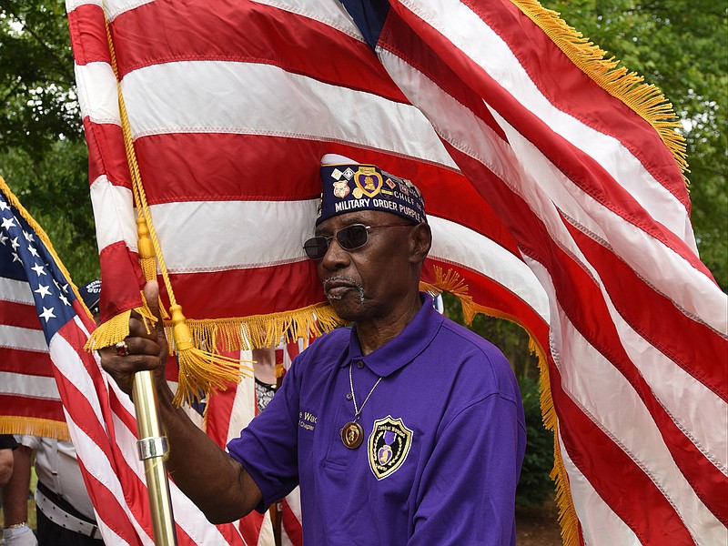 Davie Wade carries the flag for the Ernie Pyle Chapter 1945 Monday at the Memorial Day program at Chattanooga National Cemetery.