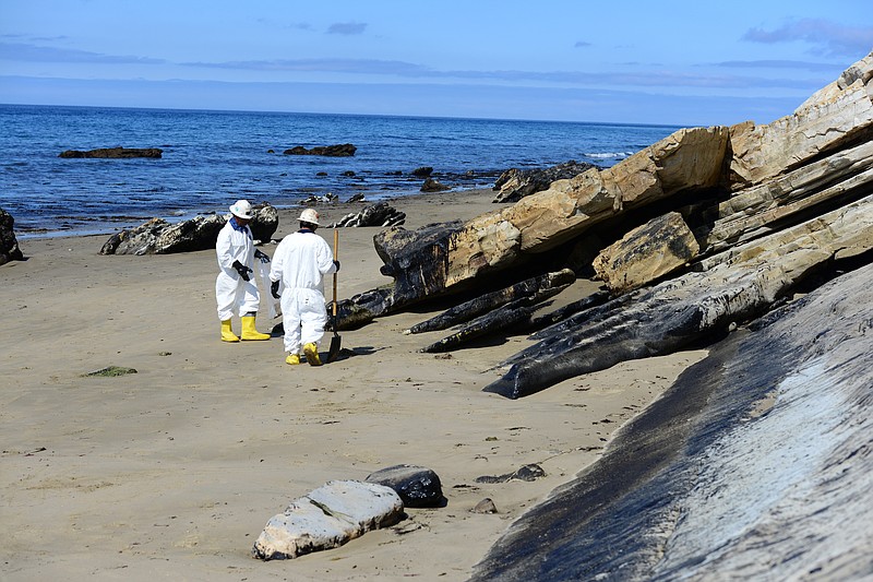 
              In this Saturday, May 23, 2015 photo released by the U.S. Coast Guard, two cleanup crew members work to remove oil from the sand along a portion of soiled coastline near Refugio State Beach,  north of Goleta, Calif. Oil spilled from a pipeline resulted in the cleanup efforts at the onshore site and along several miles of California coastline. (Chief Petty Officer David Mosley/U.S. Coast Guard via AP)
            