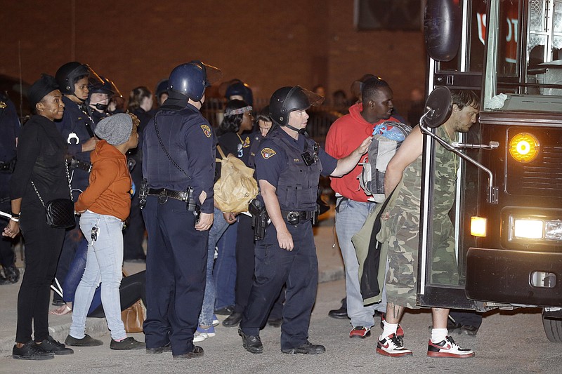 
              Protesters are escorted to a bus for transport after getting arrested after protesting the acquittal of Cleveland police officer Michael Brelo Saturday, May 23, 2015, in Cleveland. The acquittal came at a time of nationwide tension among police and black citizens punctuated by protests over the deaths of black suspects at the hands of white officers — and following a determination by the U.S. Department of Justice that Cleveland police had a history of using excessive force and violating civil rights. (AP Photo/Tony Dejak)
            
