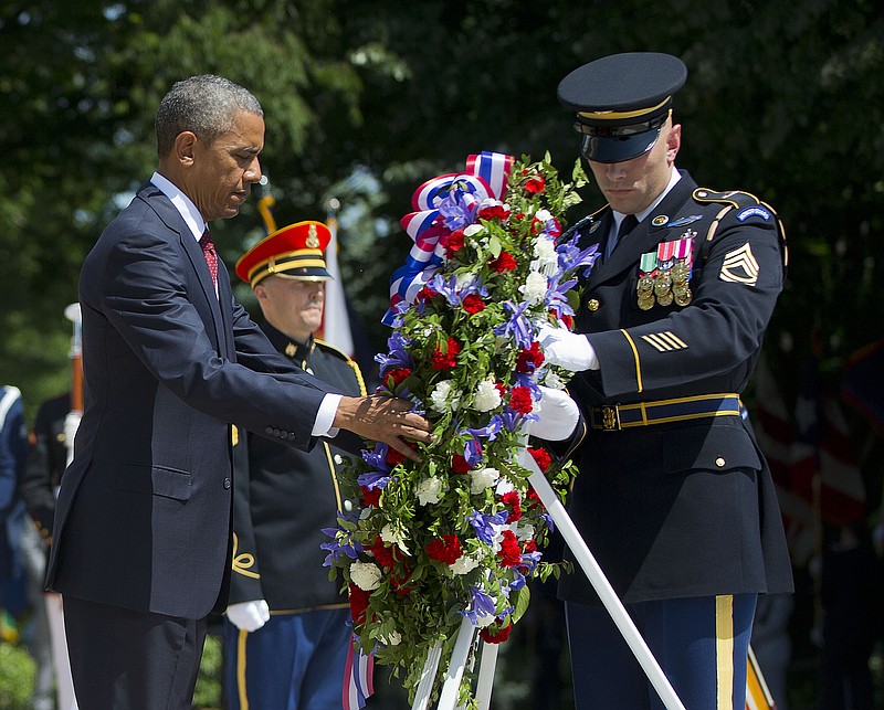 President Barack Obama and with the aid of Sgt. 1st Class John C. Wirth lays a wreath at the Tomb of the Unknowns, on Memorial Day, Monday, May 25, 2015, at Arlington National Cemetery in Arlington, Va.