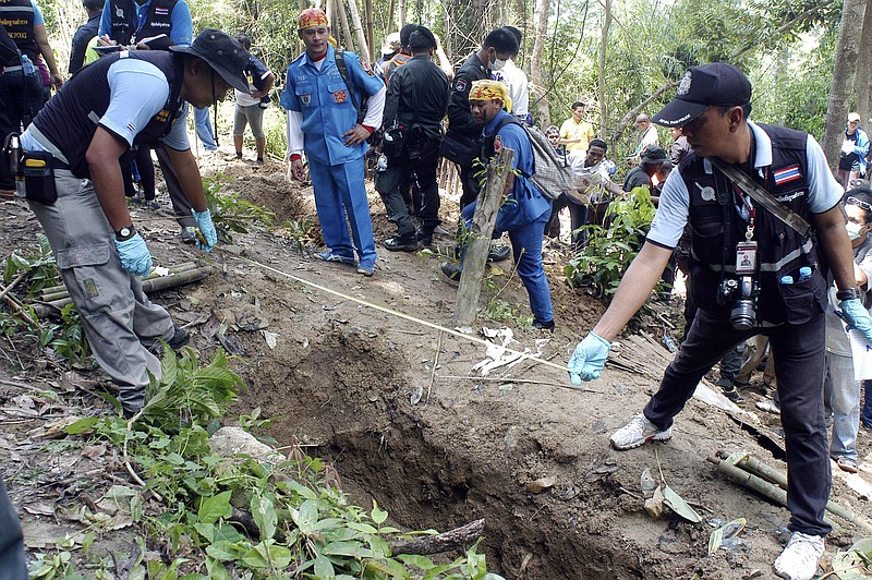 Thai police officials measure a shallow grave in Padang Besar, Songkhla province, southern Thailand, in this May 2, 2015 file photo.