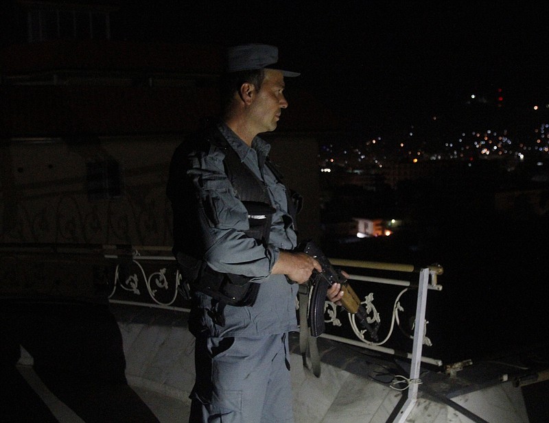 
              An Afghan security officer takes a position at a house near an ongoing attack on a guesthouse in Kabul Afghanistan, Wednesday, May 27, 2015. Heavy gunfire and explosions echoed through an upscale neighborhood in Afghanistan's capital late Tuesday night, as police surrounded a guesthouse popular with foreigners thought to be under attack by insurgents. (AP Photo/Allauddin Khan)
            