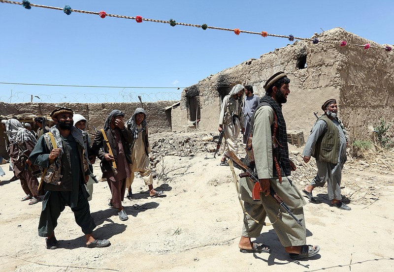 
              In this Thursday, May 21, 2015 photo, local militia group fighters walk past a building torched by Taliban fighters at Talawka village in Kunduz province, north of Kabul, Afghanistan. Fighting has been raging in Kunduz for more than a month. Pushed back by army reinforcements that arrived days after the assault began, insurgents now occupy villages in Gor Tepa, 15 kilometers (12 miles) from the provincial capital, also called Kunduz. (AP Photo/Rahmat Gul)
            