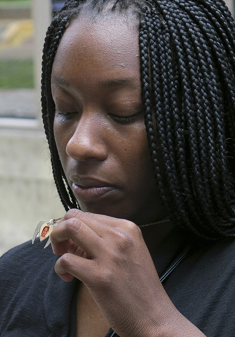 
              FILE - In this April 24, 2014 file photo, Tarshia Williams displays a pendant with her daughter, Talia's face on it outside of a federal courthouse in Honolulu. The U.S. government will pay Williams from Atlanta, $2 million for the Hawaii beating death of her 5-year-old daughter at the hands of a former soldier. The settlement amount was announced Tuesday, May 26, 2015, at a brief hearing in federal court in Honolulu. (AP Photo/Sam Eifling, File)
            