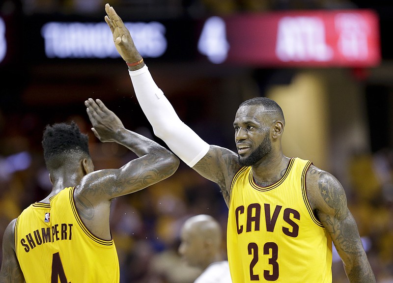 Cleveland Cavaliers forward LeBron James (23) high fives guard Iman Shumpert (4) during a timeout in the first half of Game 4 of the NBA basketball Eastern Conference Finals against the Atlanta Hawks on Tuesday, May 26, 2015, in Cleveland.