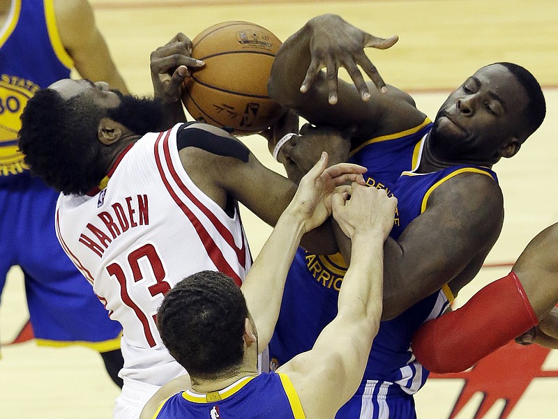 Houston Rockets guard James Harden (13) and Golden State Warriors forward Draymond Green (23) grapple for the ball as guard Klay Thompson (11) reaches in during the second half in Game 4 of the NBA basketball Western Conference finals Monday, May 25, 2015, in Houston.