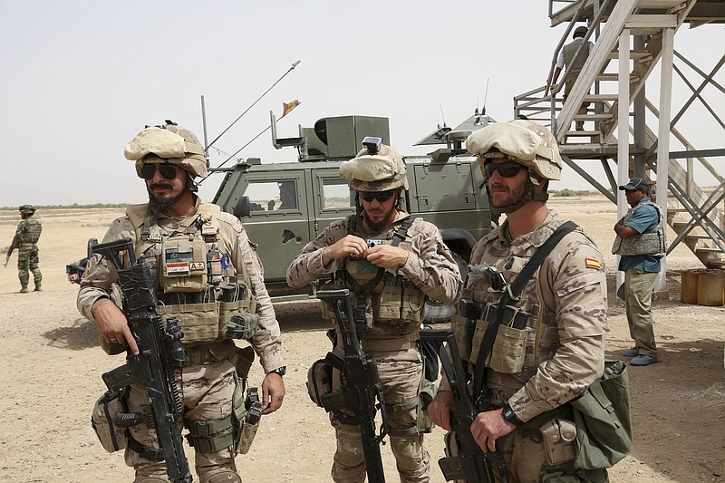 
              Spanish soldiers prepare to participate in a training mission with an Iraqi army soldier, left, outside Baghdad, Iraq, Wednesday, May 27, 2015. Islamic State extremists unleashed a wave of suicide attacks targeting the Iraqi army in western Anbar province, killing at least 17 troops in a major blow to government efforts to dislodge the militants from the sprawling Sunni heartland, an Iraqi military spokesman said Wednesday. (AP Photo/Khalid Mohammed)
            