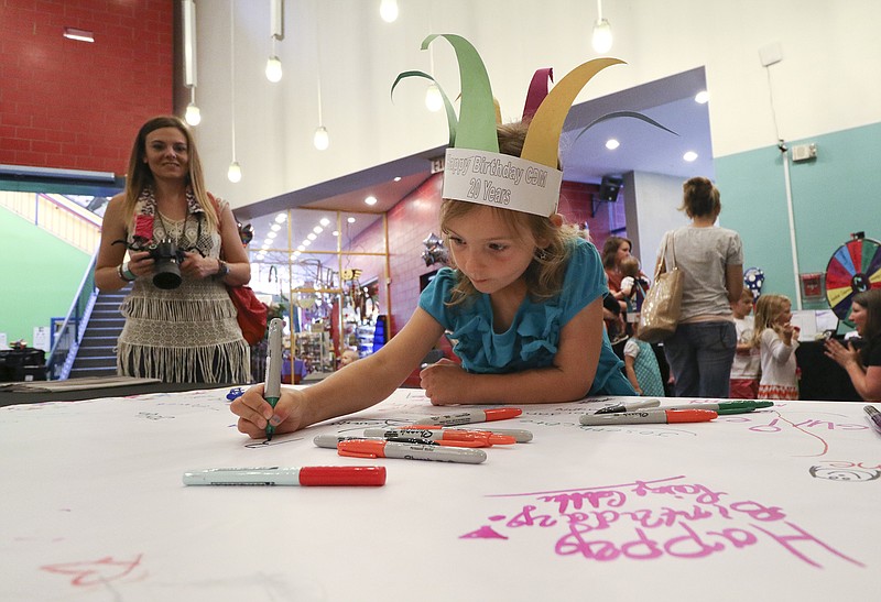 Heather WIlken, left, watches as her five-year-old daughter Brynn signs a birthday card during the Creative Discovery Museum's 20th birthday party on Tuesday, May 26, 2015. 