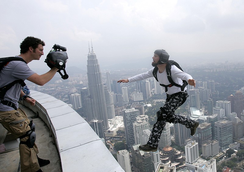 
              FILE - In this Oct. 24, 2009 file photo, an unidentified BASE jumper leaps from the height of 300 meters off of Malaysia's landmark KL Tower, the 421-meter (1,381-foot) broadcasting tower, in Kuala Lumpur, Malaysia. The sport has come under increased scrutiny in 2015 due to the recent deaths of several BASE jumpers. (AP Photo/Lai Seng Sin, file)
            