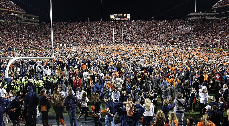 Auburn fans react at the end of a win over Alabama during the second half of an NCAA college football game in Auburn, Ala., Saturday, Nov. 30, 2013. Auburn beat Alabama 34-28. 