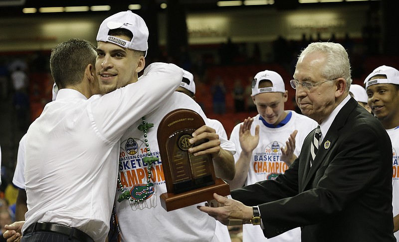 Florida guard Scottie Wilbekin hugs his coach Florida head coach Billy Donovan after receiving the MVP trophy from DEC Commissioner Mike Slive as SEC after the second half of an NCAA college basketball game against Kentucky in the Championship round of the Southeastern Conference men's tournament, Sunday, March 16, 2014, in Atlanta. Florida won 61-60. 