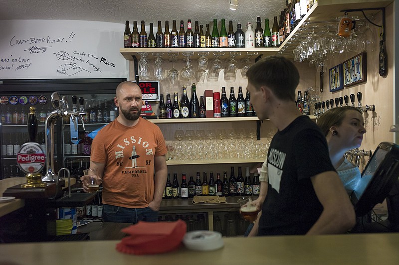 
              In this photo taken on Friday, May  22, 2015,  Stanislav Obraztsov, left, speaks to his colleagues at his craft beer bar in Moscow. The ruble’s crash in value against the dollar last year helped Russia’s nascent craft beer industry by making imported competitors more expensive. (AP Photo/Alexander Zemlianichenko)
            