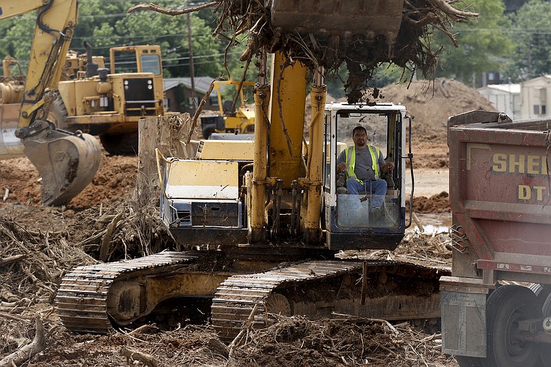 An excavator loads dirt and brush into a truck at the Ganns Middle Valley Elementary School construction site Thursday in Hixson.