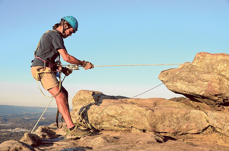 A climber prepares to descend the cliff at Lookout Mountain's Sunset Rock.