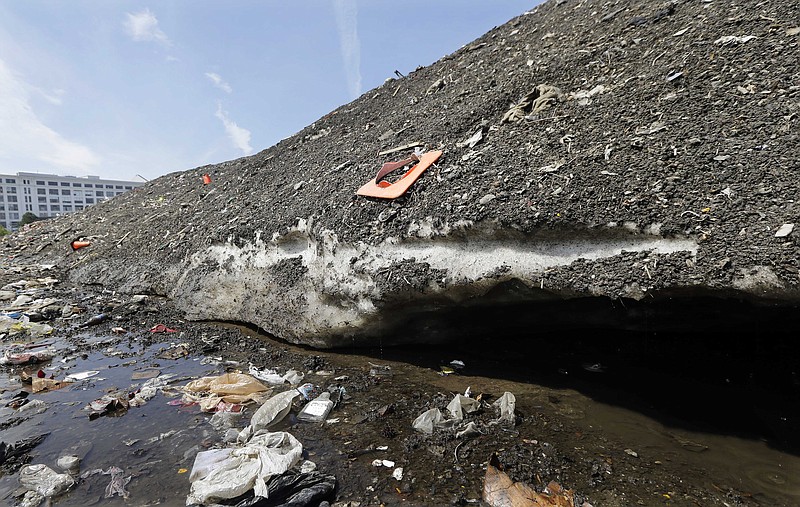 
              Debris covers a lingering snow pile, amassed during the record-setting winter, Thursday, May 28, 2015, the Seaport District in Boston. A 75-foot-high snow mound in the Seaport District has been reduced to a three-story pile of dirt and trash, including bicycles, traffic cones and even half a $5 bill, that remains encrusted in solid ice. Crews have been working for six weeks to clean away the trash as it breaks free from the mound. So far, they have pulled 85 tons of debris from the pile. (AP Photo/Elise Amendola)
            