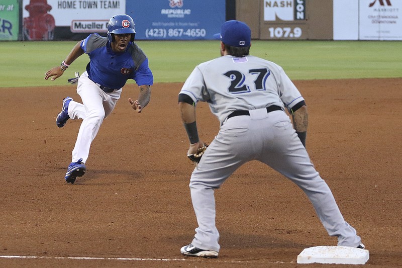 Biloxi's Brandon Macias (27) waits for a throw as Chattanooga Lookouts outfielder Byron Buxton (7) prepares to slide into third before continuing on to home to score at AT&T Field in Chattanooga on Friday, May 29, 2015.