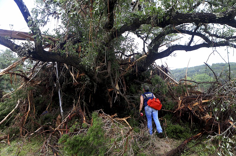 
              Alaena Tate, a member of a search and rescue team, looks through debris for people who were still missing after heavy flooding Wednesday, May 27, 2015, around Umphery Ranch located between Wimberley and San Marcos, Texas. The search went on for about a dozen people, including a group that disappeared after a vacation home was swept down a river and slammed into a bridge. (Gabe Hernandez/Corpus Christi Caller-Times via AP) MANDATORY CREDIT; MAGS OUT; TV OUT
            