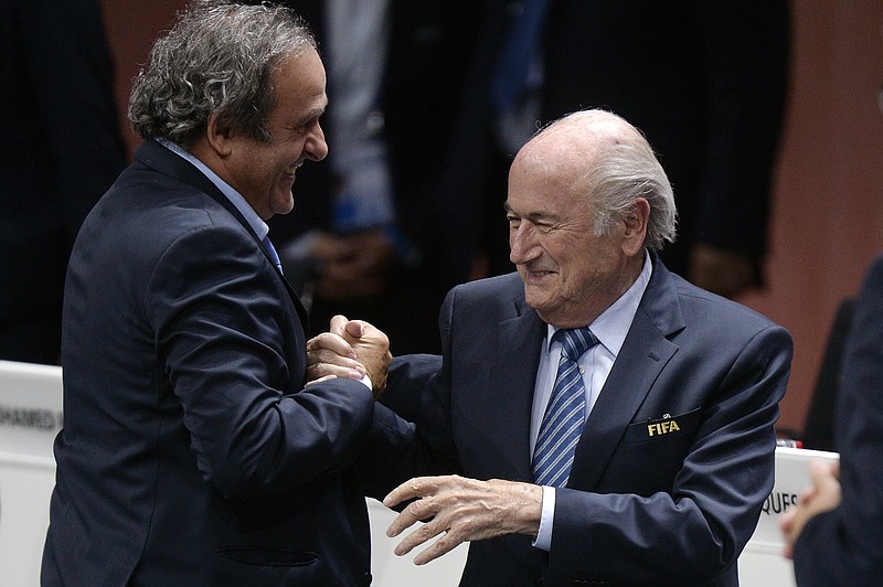 
              Re-elected FIFA president Sepp Blatter, right,  is congratulated by FIFA vice president and UEFA president Michel Platini after his speech during the 65th FIFA Congress held at the Hallenstadion in Zurich, Switzerland, Friday, May 29, 2015. Blatter has been re-elected as FIFA president for a fifth term, chosen to lead world soccer despite separate U.S. and Swiss criminal investigations into corruption. The 209 FIFA member federations gave the 79-year-old Blatter another four-year term on Friday after Prince Ali bin al-Hussein of Jordan conceded defeat after losing 133-73 in the first round.  (Patrick B. Kraemer / Keystone via AP)
            