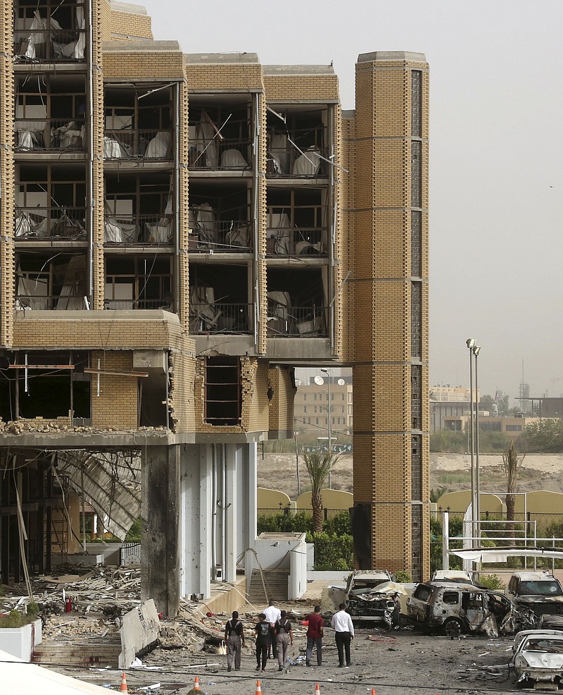 
              Civilians and security forces inspect the aftermath of a car bomb attack in the parking lot of Babylon  hotel in Baghdad, Iraq, Friday, May 29, 2015. Two separate car bombs inside parking lots of two downtown hotels have killed and wounded civilians late Thursday, authorities said. (AP Photo/Hadi Mizban)
            