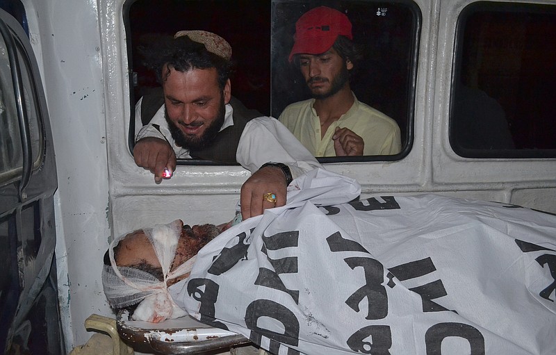 
              A Pakistani looks the lifeless body of his relative, who was killed by gunmen when they hijacked two buses, as the bodies of victims are brought Quetta, Pakistan, Saturday May 30, 2015. Officials say Pakistani security forces have launched a major operation to hunt down gunmen who hijacked two buses and killed more than a dozen passengers in the country's southwest before fleeing. (AP Photo/Arshad Butt)
            