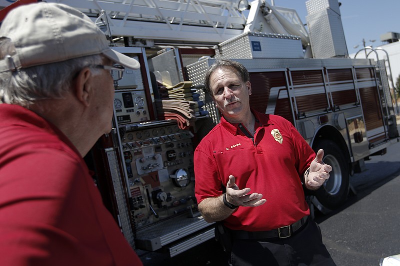 Interim fire chief Chris Adams, right, talks with Mike Jump before a meeting Saturday, May 23, 2015, held in the parking lot of Redemption Point Church in Chattanooga to discuss the construction of a new Fire Station #5. Some residents are concerned about the change, which would include a switch from 2 old fire trucks to a single new truck.