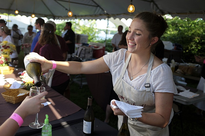 Errin Cusack pours a glass of wine for a guest Saturday, May 30, 2015, at the Chattanooga Symphony and Opera's UnCorked wine-tasting fundraiser at Renaissance Park in Chattanooga.