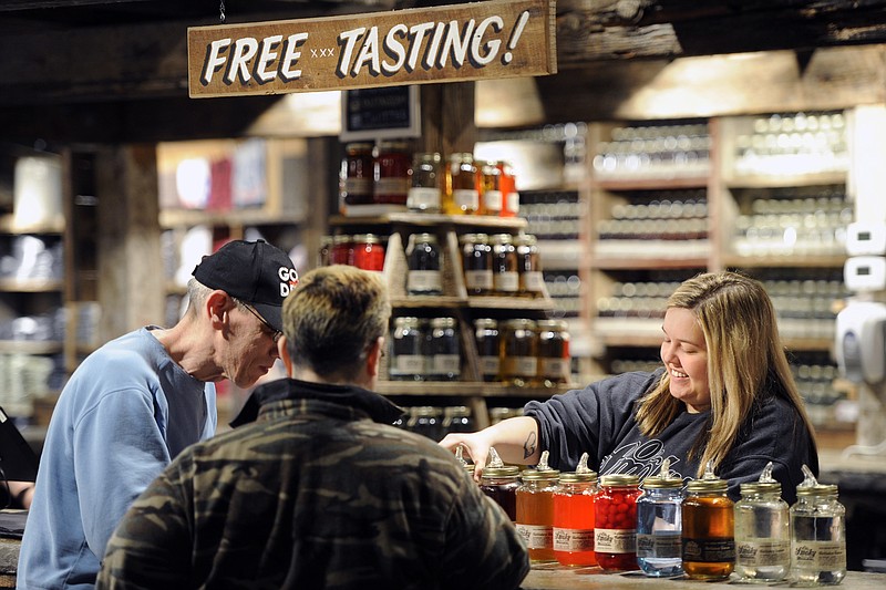 In this April 16, 2015, photo, Brittany Ogle pours moonshine samples for customers at Ole Smoky Distillery in Gatlinburg, Tenn. 