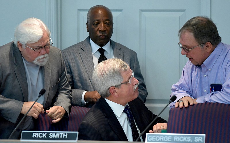 Superintendent Rick Smith, seated, talks with school board members David Testerman, George Ricks, Sr., and Dr. Steve Highlander, from left, before the Hamilton County Board of Education meets to rework their 2016 budget request Monday, June 1,  2015, in Chattanooga.