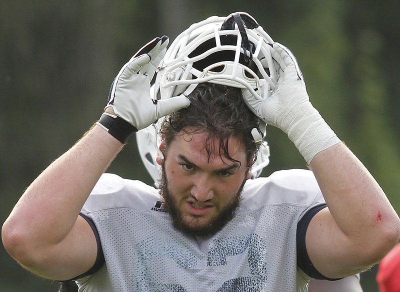 Staff photo / UTC offensive lineman Corey Levin removes his helmet during practice on Aug. 1, 2014, at Scrappy Moore Field.