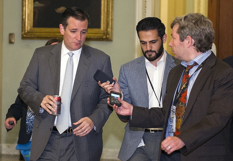 Sen. Ted Cruz., R-Texas., left, speaks with reporters as he walks to the Senate Chamber for a special session of the Senate to extend surveillance programs, in Washington on Sunday, May 31, 2015. 