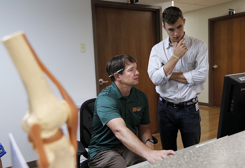 Orthopedic Dr. Jad Dorizas, left, talks with college student Brock Rustand, who is considering a career in orthopedics in the offices of UT Erlanger OrthoSouth in this June 3, 2015, photo.