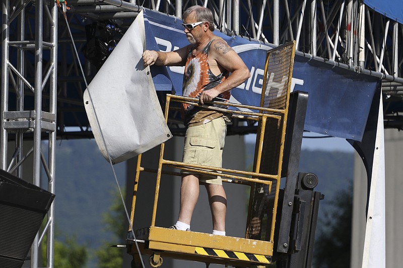 Chattanooga resident Rice Crabtree puts up the Bud Light Stage banner on June 4, 2015, in preparation for the 2015 Riverbend Festival in downtown Chattanooga which runs from June 5 through June 13.  