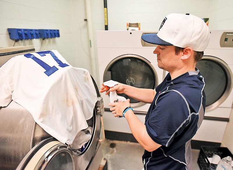 Lookouts clubhouse manager Nic Larson pre-treats laundry after a recent game against the Smokies. His secret to beating tough stains? A dual-step product called "Slide Out."