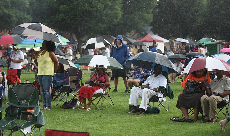 Staff Photo by Angela Lewis Foster/ The Chattanooga Times Free Press- 6/08/15
People raise their umbrellas as the rain begins Monday during a Deacon Bluz performance on the Bessie Smith Hall Stage at the Bessie Smith Strut.