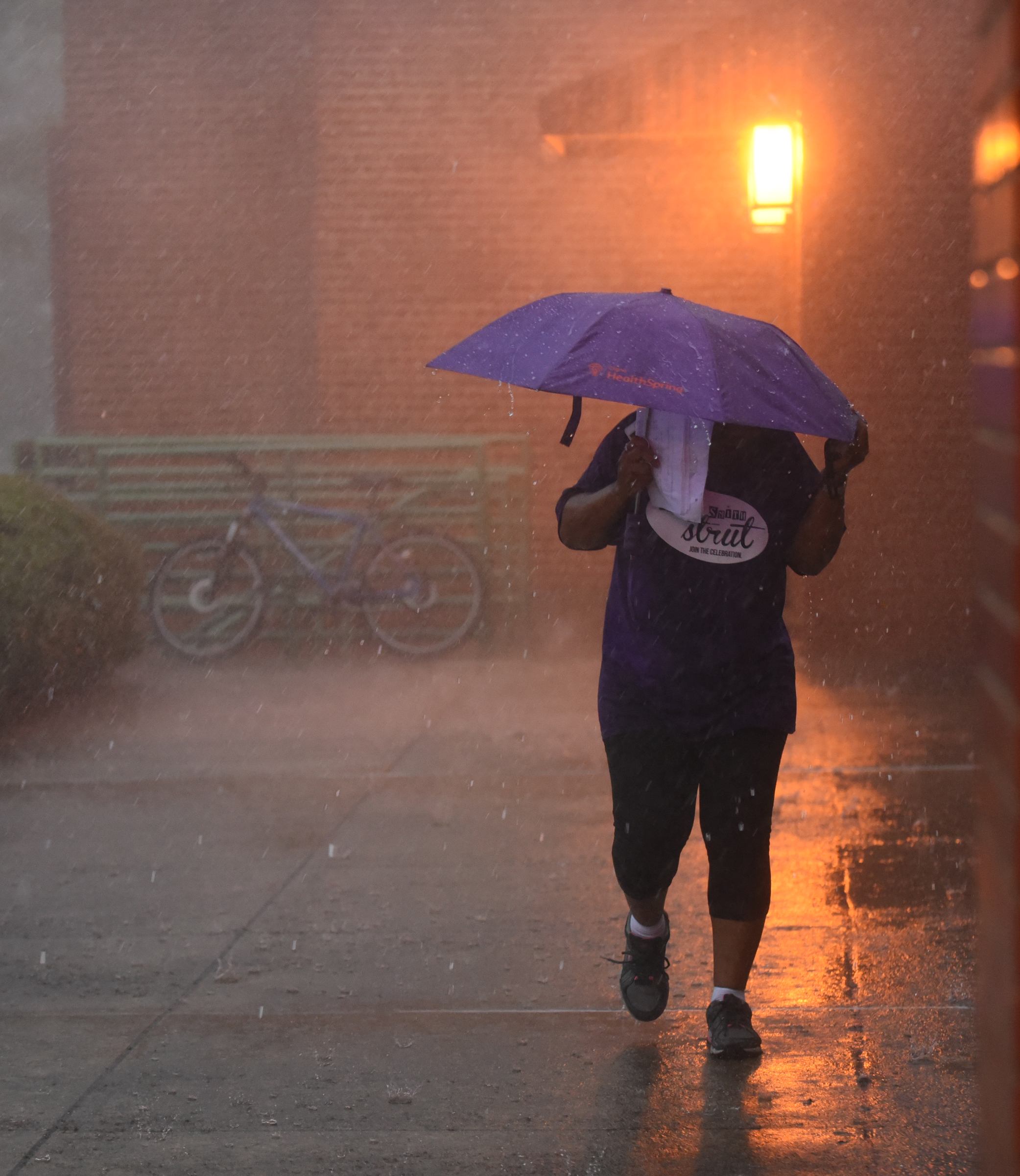 Staff Photo by Angela Lewis Foster/ The Chattanooga Times Free Press- 6/08/15
A woman makes her way through the rain into the dry Bessie Smith Cultural Center Monday at the Bessie Smith Strut.