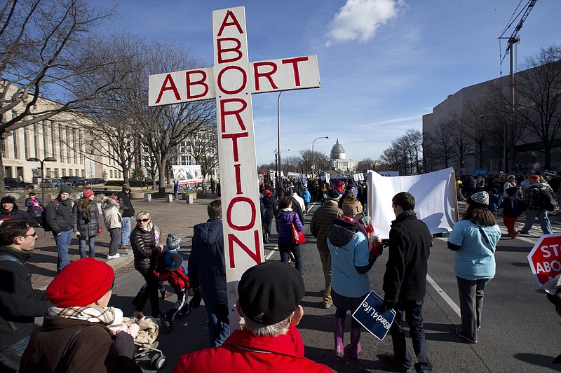 Roy Rohn, 87, of Riverdale, Md., carries a cross that says "abort abortion" as pro-life supporters march toward the Supreme Court on the National Mall in Washington in January during the annual March for Life.