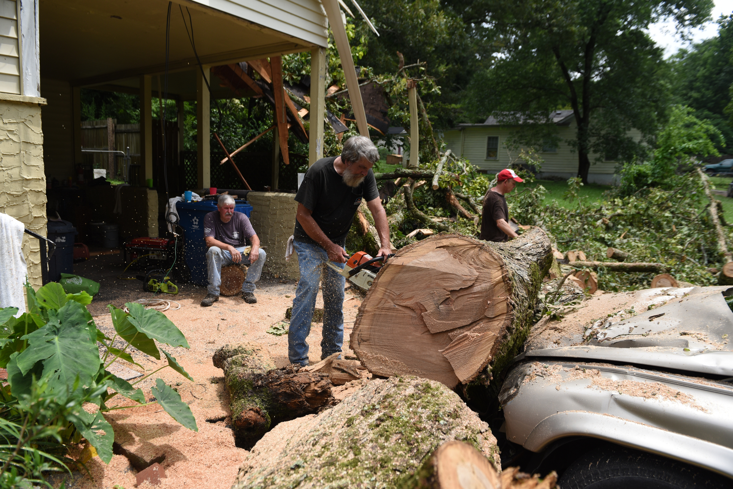 Staff photo by John Rawlston/Chattanooga Times Free Press - {iptcmonthname3 {iptcday}, 2015
Ronnie Morgan, right, gets help from neighbors Kenneth Withrow, left, and Ron Hoyle as he cleans up damage from Monday night storms on Tuesday, June 9, 2015, in Rossville, Ga.