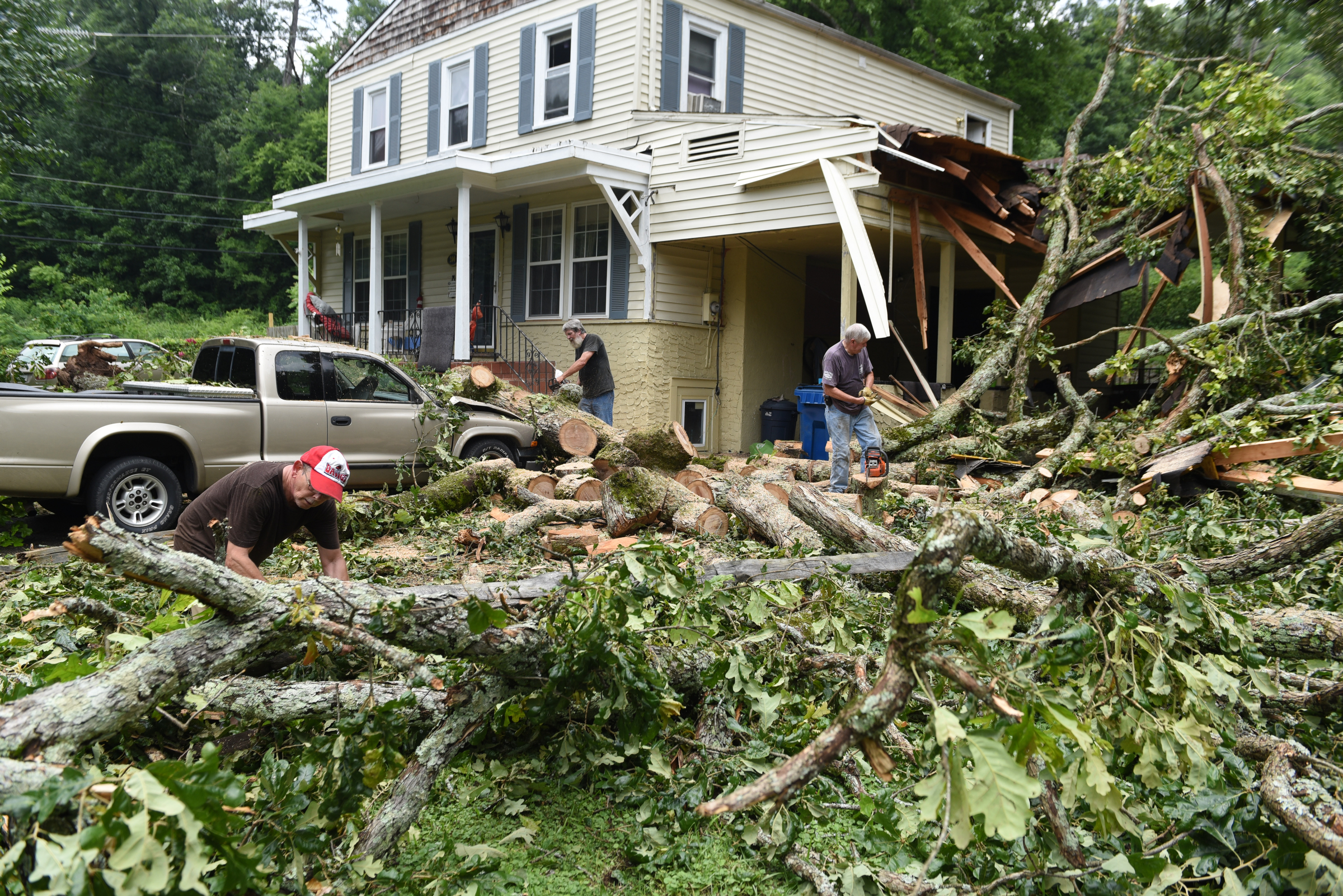 Staff photo by John Rawlston/Chattanooga Times Free Press - {iptcmonthname3 {iptcday}, 2015
Ronnie Morgan, left, gets help from neighbors Kenneth Withrow, right, and Ron Hoyle as he cleans up damage from Monday night storms on Tuesday, June 9, 2015, in Rossville, Ga.