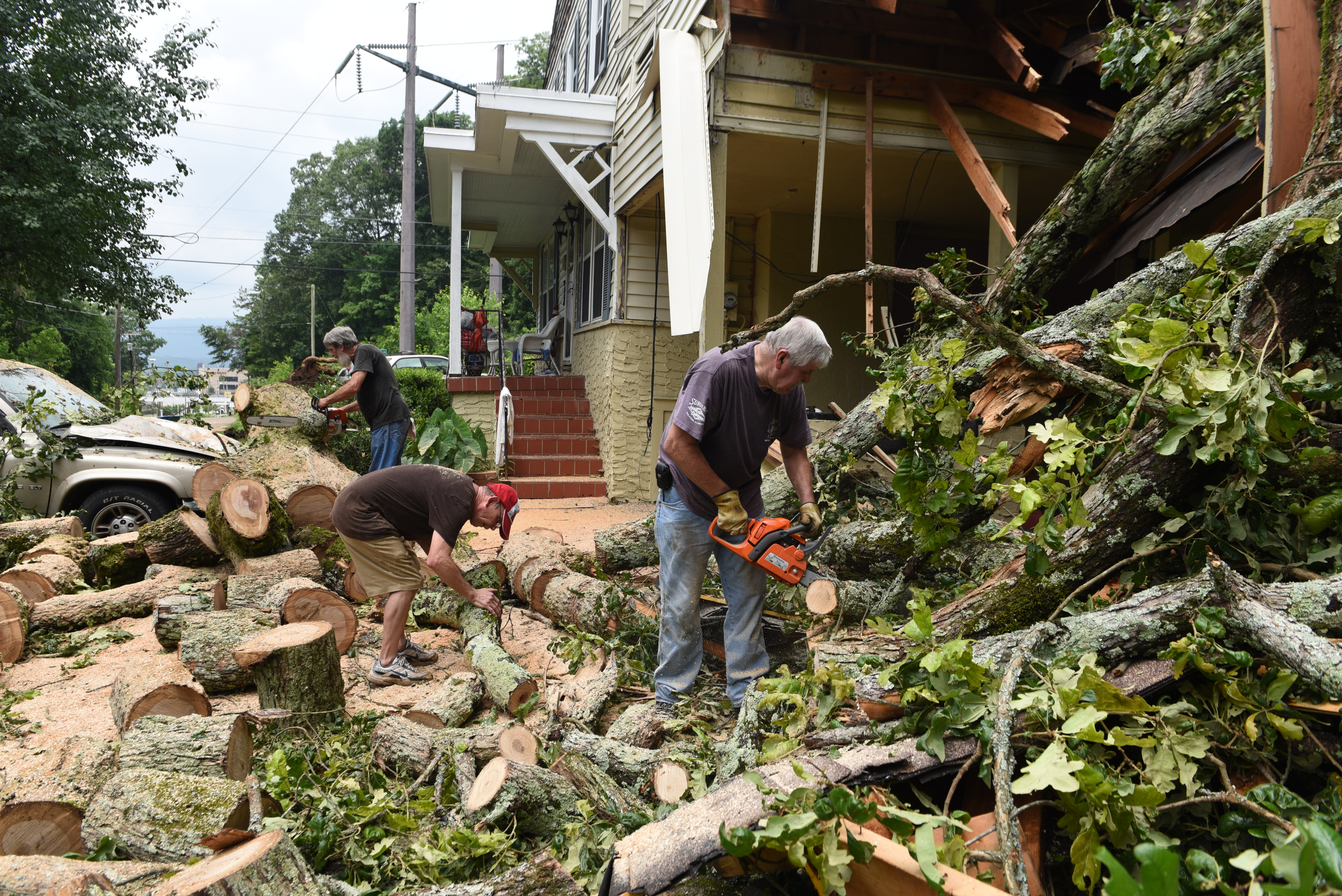 Staff photo by John Rawlston/Chattanooga Times Free Press - {iptcmonthname3 {iptcday}, 2015
Ronnie Morgan, center, gets help from neighbors Kenneth Withrow, right, and Ron Hoyle as he cleans up damage from Monday night storms on Tuesday, June 9, 2015, in Rossville, Ga.