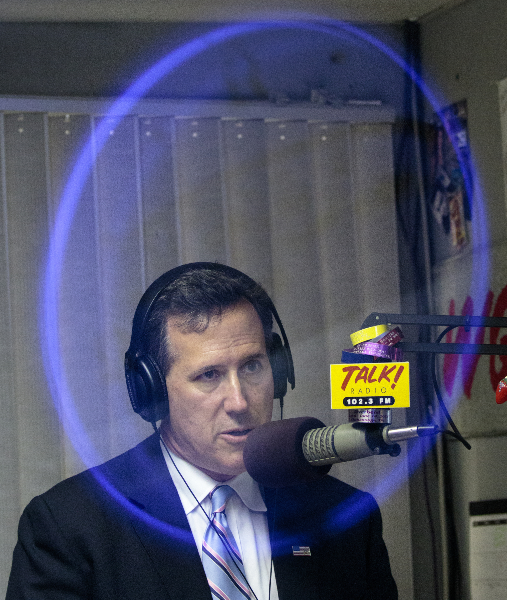 Staff photo by Doug Strickland
The reflection of a studio clock on the glass of a window surrounds candidate for the GOP presidential nomination and former U.S. Sen. Rick Santorum as he is interviewed on Talk! Radio 102.3 on Wednesday, June 10, 2015, at Cumulus Media in Chattanooga, Tenn. Sen. Santorum later spoke at the Hamilton County GOP's Lincoln Day dinner at the Chattanoogan Hotel.