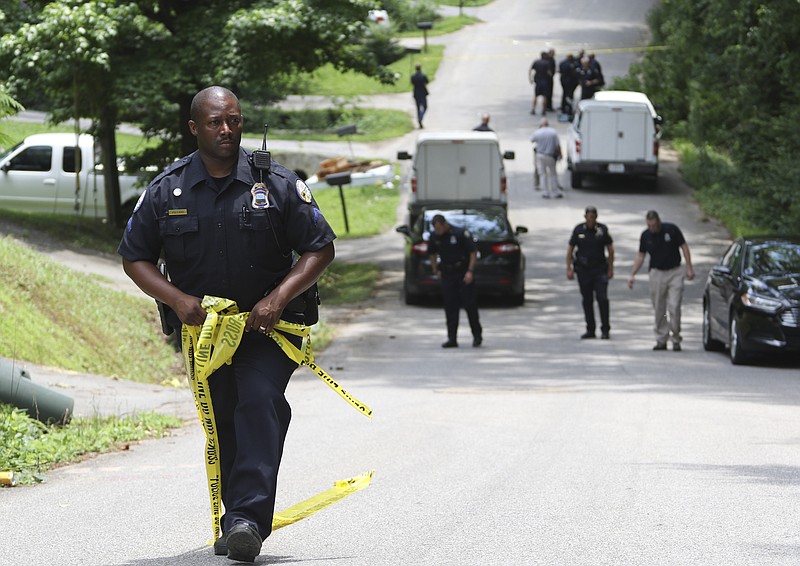 Chattanooga Police Officer Mark Pollard moves the crime scene back as emergency personnel respond to the shooting.