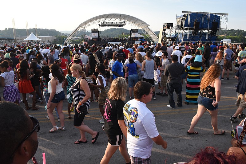 Staff photo by John Rawlston/Chattanooga Times Free Press -2015 Attendees walk on Riverfront Parkway as Doug E. Fresh and Slick Rick perform the early show on the Coca Cola Stage at the Riverbend Festival on Wednesday, June 10, 2015, in Chattanooga, Tenn. Reserved seating is seen below the white fence.