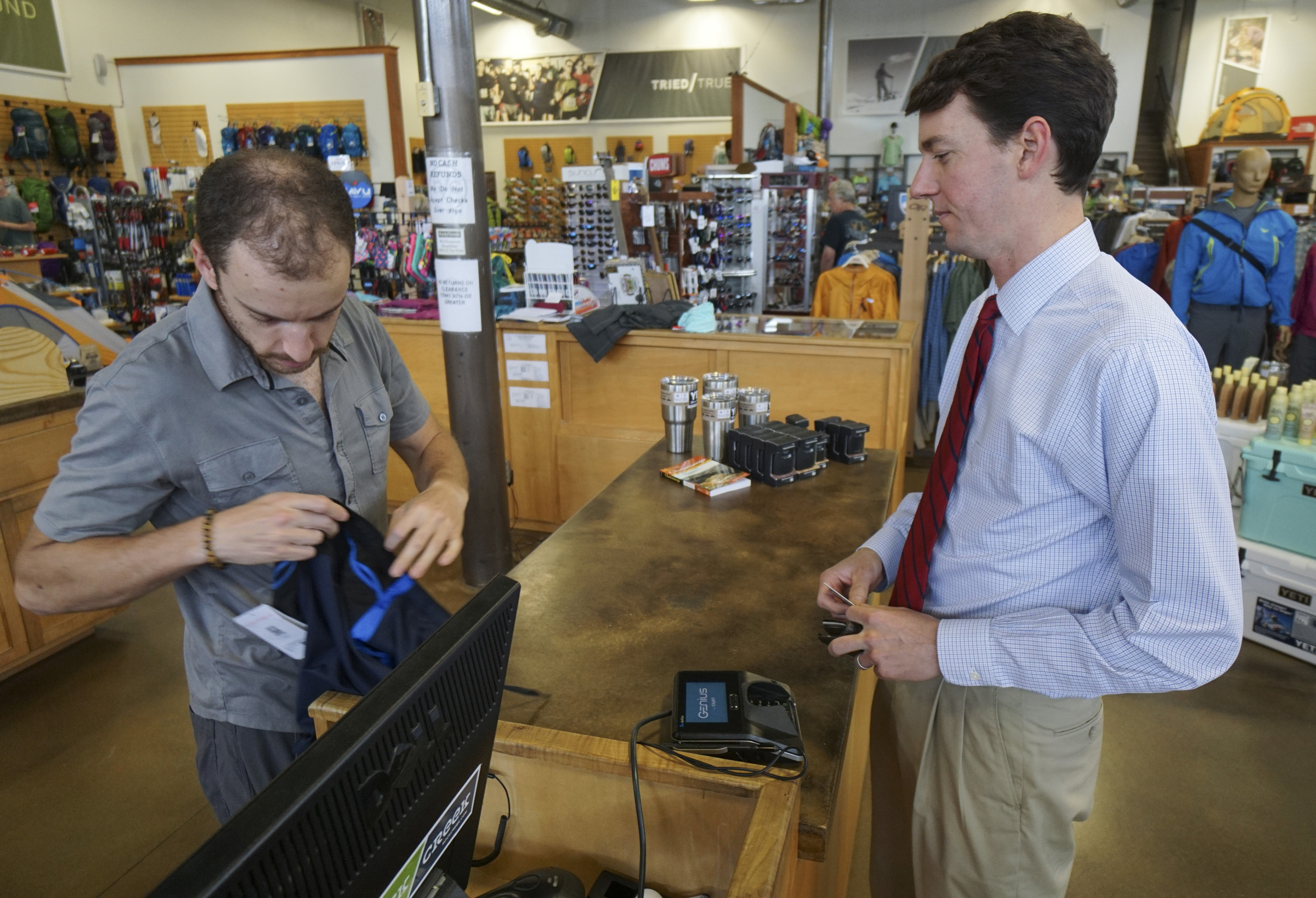 Staff Photo by Dan Henry / The Chattanooga Times Free Press- 6/9/15. Jeremy Parker, left, assists Lance Pope with a purchase of new running shorts while at Rock Creek's flagship store in North Chattanooga on June 9, 2015.