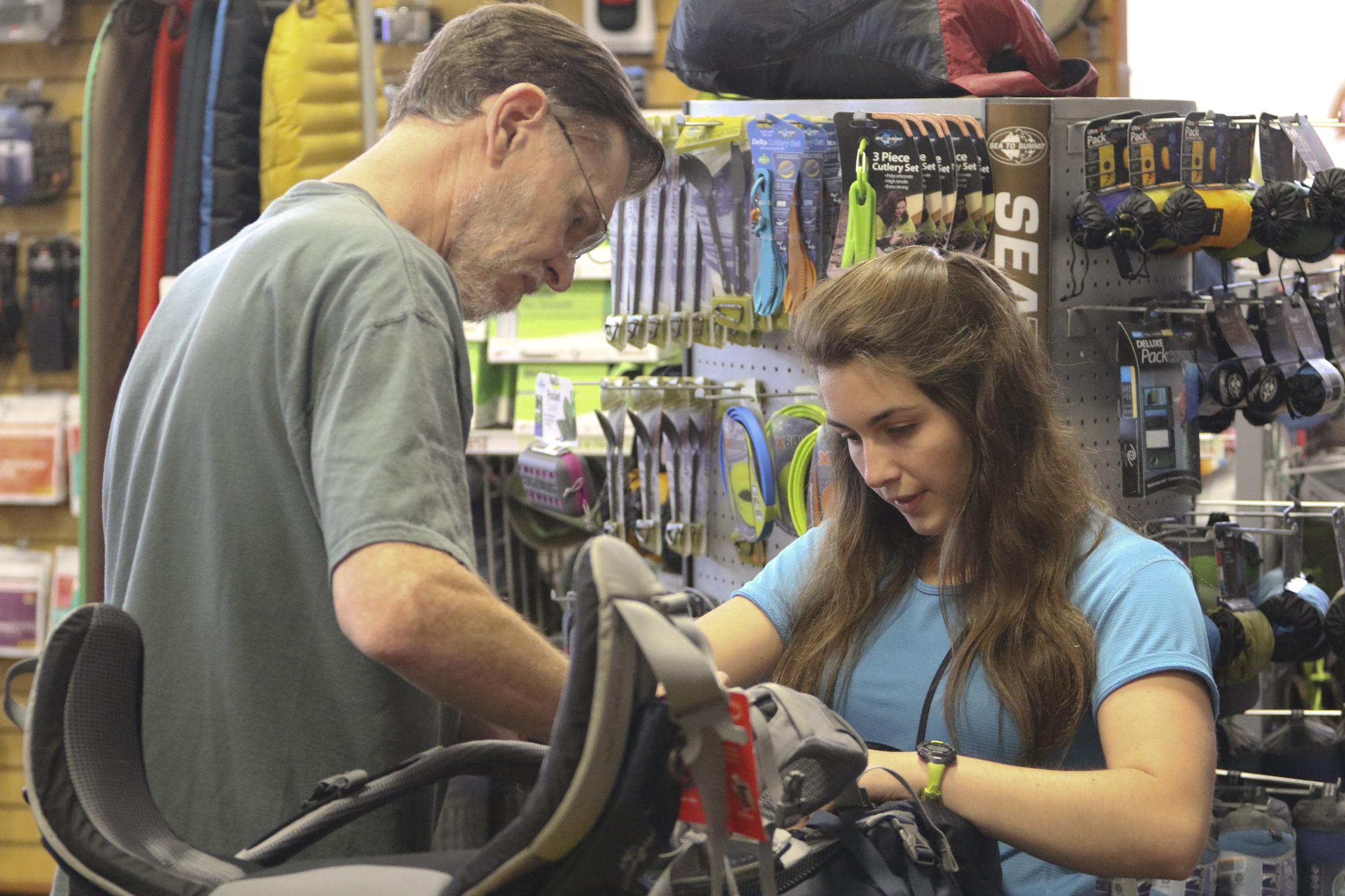 Staff Photo by Dan Henry / The Chattanooga Times Free Press- 6/9/15. Sales associate Aubrey Gardin fits a backpack to Walter Clack while at Rock Creek's flagship store in North Chattanooga on June 9, 2015.