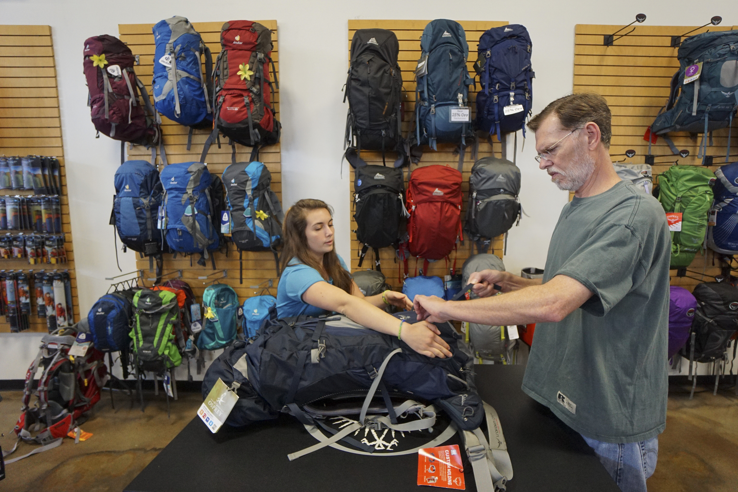 Staff Photo by Dan Henry / The Chattanooga Times Free Press- 6/9/15. Sales associate Aubrey Gardin fits a backpack to Walter Clack while at Rock Creek's flagship store in North Chattanooga on June 9, 2015.