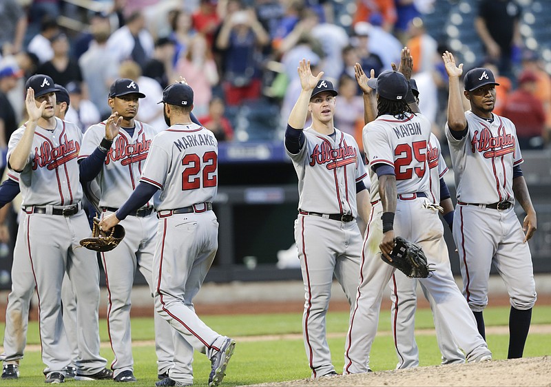 tlanta Braves' Nick Markakis (22) and Cameron Maybin (25) celebrate with teammates after a baseball game against the New York Mets Saturday, June 13, 2015, in New York. The Braves won the game 5-3.