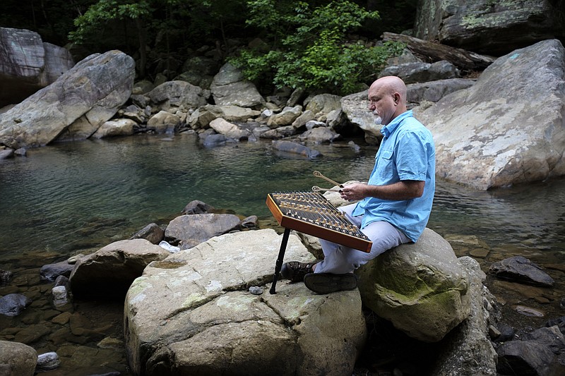 Staff photo by Doug Strickland
Musician Dan Landrum plays the hammer dulcimer on a rock in Suck Creek on Friday, June 12, 2015, in Chattanooga, Tenn. The hammer dulcimer is a precursor instrument to the piano.