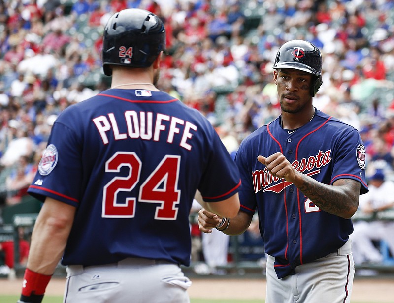 Minnesota Twins' Byron Buxton, right, is congratulated by Trevor Plouffe (24) after scoring the go-ahead run on a double by Eddie Rosario against the Texas Rangers during the ninth inning of a baseball game, Sunday, June 14, 2015, in Arlington, Texas. The Twins won 4-3. (AP Photo/Jim Cowsert)