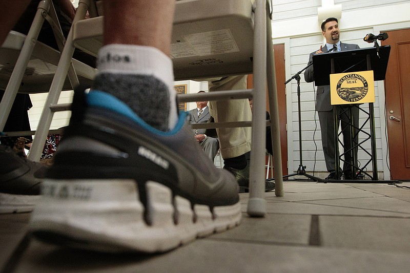 Staff photo by Doug Strickland
A spectator wears running shoes as Chattanooga Sports Committee President Tim Morgan talks about the creation of the new Chattanooga Marathon at a news conference Thursday, June 18, 2015, at Coolidge Park in Chattanooga, Tenn. The marathon is set to take place March 4-6 of 2016.
